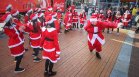 Младежи, облечени като Дядо Коледа, танцуват в центъра на София